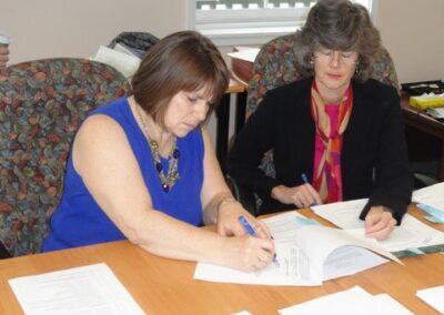two women sign documents